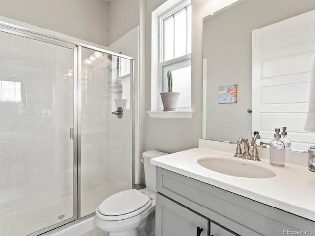 full bath featuring a stall shower, toilet, and vanity