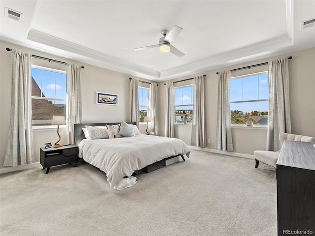 bedroom featuring light carpet, visible vents, and a tray ceiling