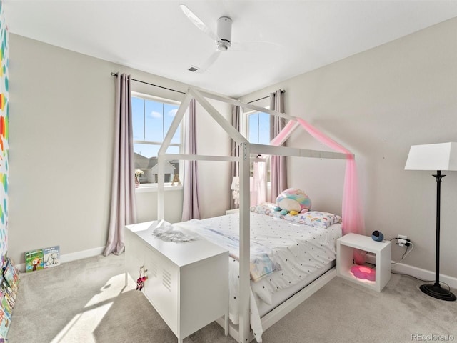 carpeted bedroom with a ceiling fan, visible vents, and baseboards