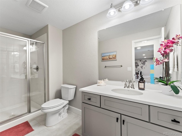 bathroom featuring vanity, visible vents, tile patterned flooring, a shower stall, and toilet