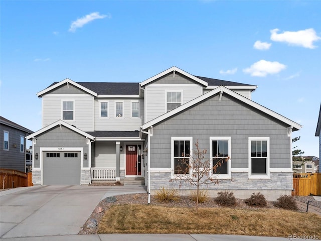 craftsman-style house with stone siding, roof with shingles, driveway, and fence