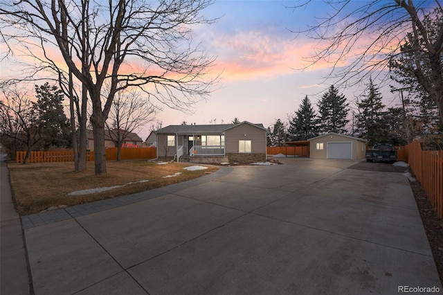 view of front of house with a garage, concrete driveway, fence, and an outdoor structure