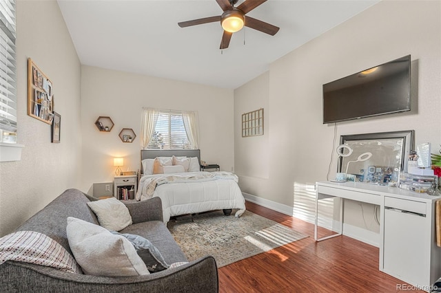 bedroom featuring ceiling fan, baseboards, and wood finished floors