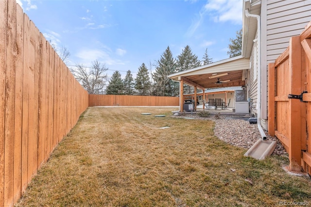 view of yard with a fenced backyard, a ceiling fan, and a patio