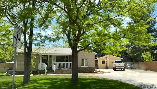 single story home featuring covered porch, fence, concrete driveway, and a front yard