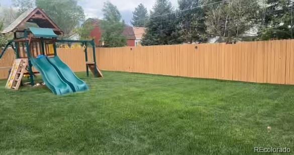 view of jungle gym with a fenced backyard and a lawn