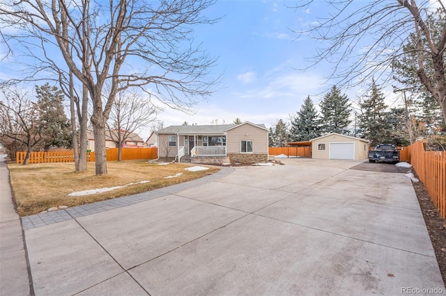 view of front of property with an outbuilding, fence, driveway, and a detached garage