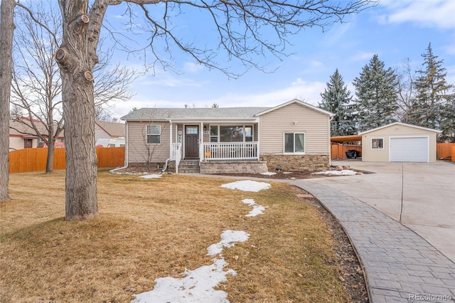 ranch-style home with covered porch, fence, stone siding, driveway, and an outdoor structure