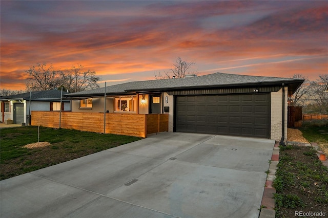 2544 S Raleigh St, Denver, CO 80219 - view of front of property with concrete driveway, an attached garage, brick siding, and a fenced front yard