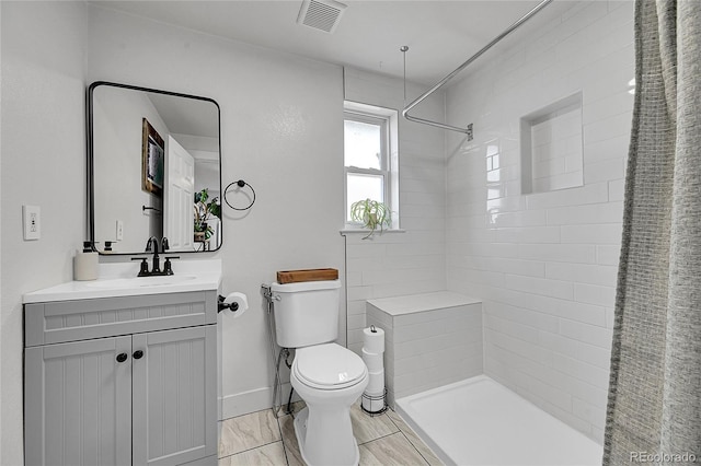 2544 S Raleigh St, Denver, CO 80219 - bathroom with toilet, tiled shower, vanity, and visible vents