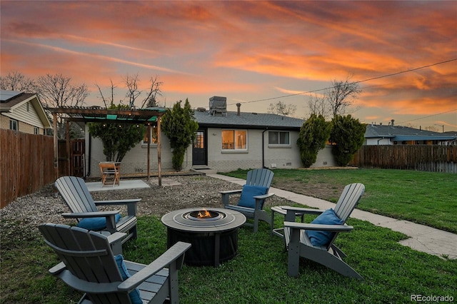 2544 S Raleigh St, Denver, CO 80219 - back of property at dusk with a patio area, a fenced backyard, a fire pit, and a lawn