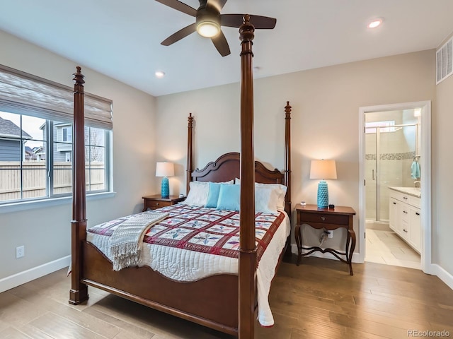 bedroom with recessed lighting, wood finished floors, baseboards, and ensuite bathroom