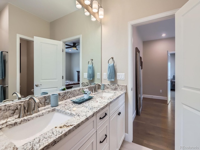 bathroom featuring a sink, double vanity, wood finished floors, and ensuite bathroom