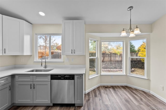 kitchen featuring plenty of natural light, sink, stainless steel dishwasher, and gray cabinets