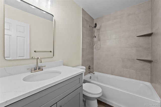 full bathroom featuring toilet, tiled shower / bath combo, and vanity