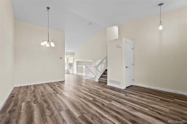 unfurnished living room with an inviting chandelier, hardwood / wood-style flooring, and high vaulted ceiling