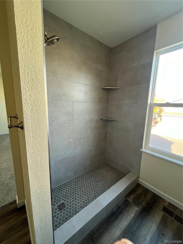 bathroom featuring tiled shower and hardwood / wood-style flooring