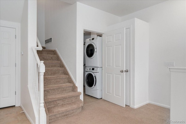 5255 Memphis St Unit 219, Denver, CO 80239 - washroom featuring stacked washing machine and dryer and light colored carpet
