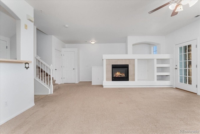 5255 Memphis St Unit 219, Denver, CO 80239 - unfurnished living room with carpet flooring, a ceiling fan, stairway, and a tile fireplace