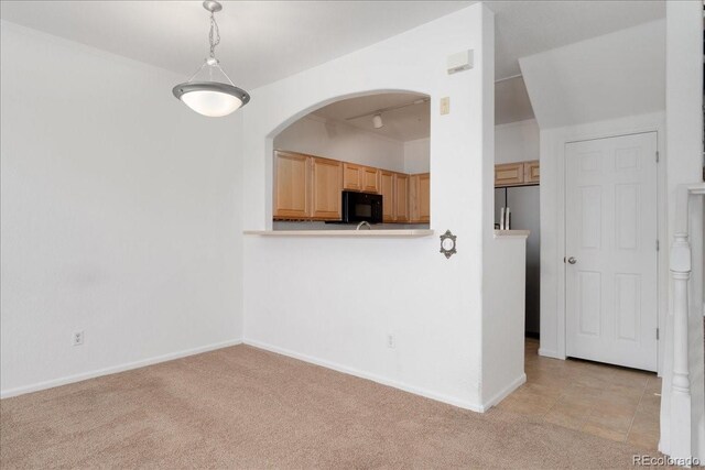 5255 Memphis St Unit 219, Denver, CO 80239 - kitchen with black microwave, light colored carpet, arched walkways, stainless steel refrigerator with ice dispenser, and light brown cabinetry