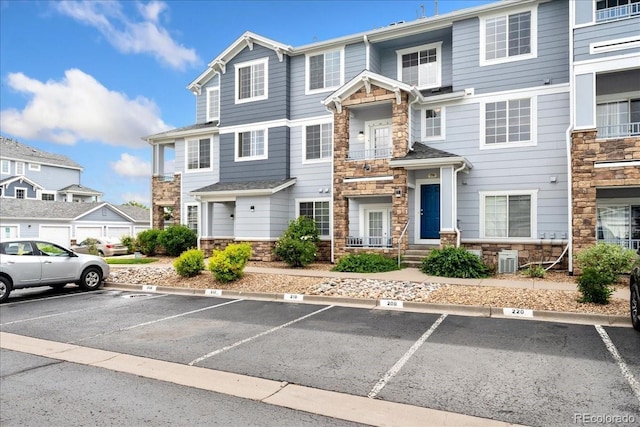 5255 Memphis St Unit 219, Denver, CO 80239 - view of front facade featuring stone siding and uncovered parking