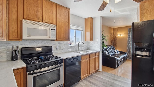 766 Fulton Ave, Brighton, CO 80601 - kitchen with black appliances, light countertops, light wood finished floors, and tasteful backsplash