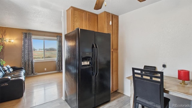 766 Fulton Ave, Brighton, CO 80601 - kitchen with black refrigerator with ice dispenser, light wood-style floors, ceiling fan, and brown cabinets