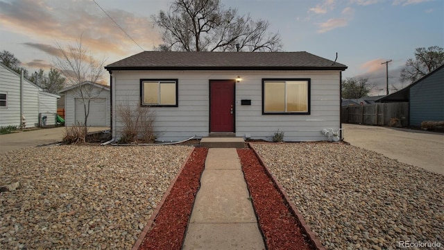766 Fulton Ave, Brighton, CO 80601 - view of front of house with driveway, a shingled roof, an outdoor structure, and a detached garage