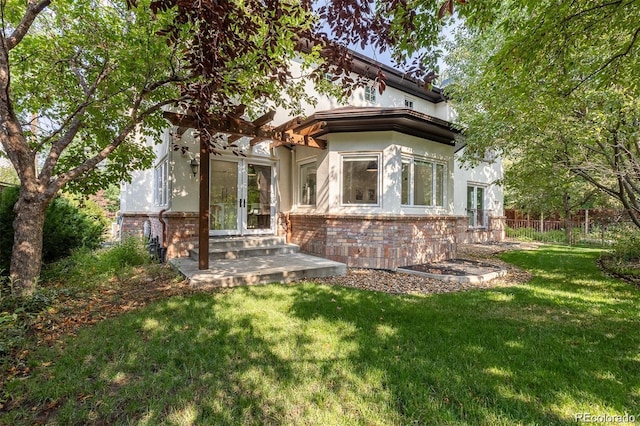 rear view of property with a yard and french doors