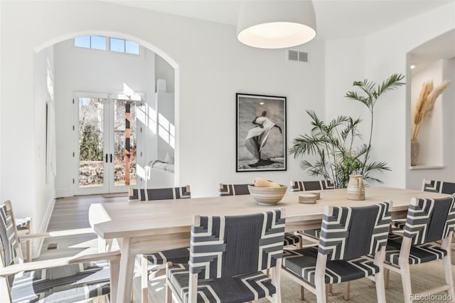 dining space featuring french doors, visible vents, and wood finished floors