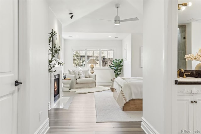 interior space with a sink, a fireplace with flush hearth, lofted ceiling, and wood finished floors