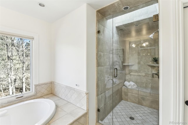 full bathroom featuring a stall shower, plenty of natural light, and a bath