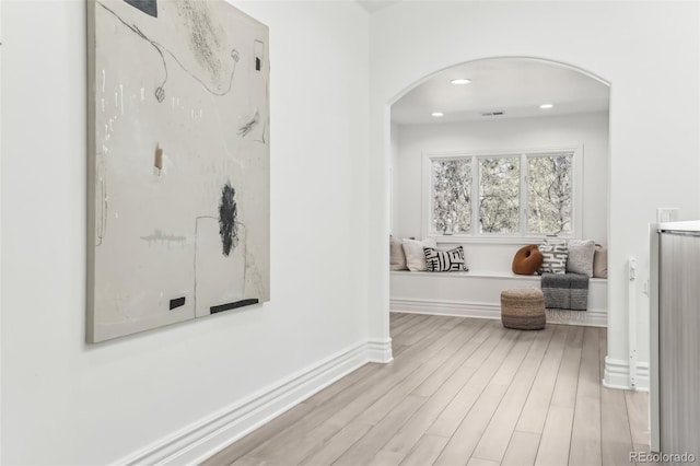 hall featuring visible vents, wood finished floors, recessed lighting, arched walkways, and baseboards