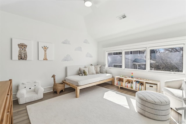 sitting room with vaulted ceiling, wood finished floors, and visible vents