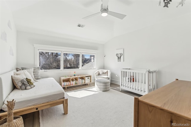 bedroom with visible vents, lofted ceiling, wood finished floors, and a ceiling fan