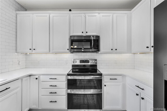 kitchen with white cabinetry, tasteful backsplash, appliances with stainless steel finishes, and light countertops