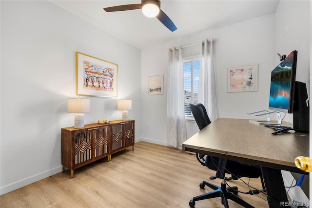 office area with baseboards, light wood-style floors, and a ceiling fan