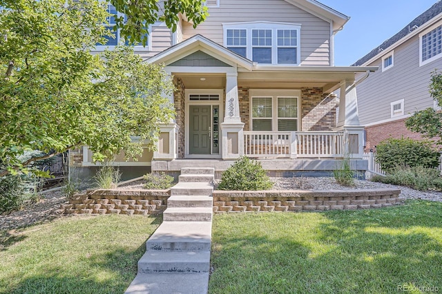 9523 Gray Ct, Westminster, CO 80031 - view of front facade with a front yard, covered porch, and brick siding