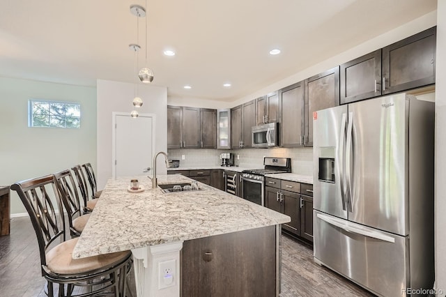 9523 Gray Ct, Westminster, CO 80031 - kitchen featuring appliances with stainless steel finishes, dark wood finished floors, dark brown cabinetry, backsplash, and recessed lighting