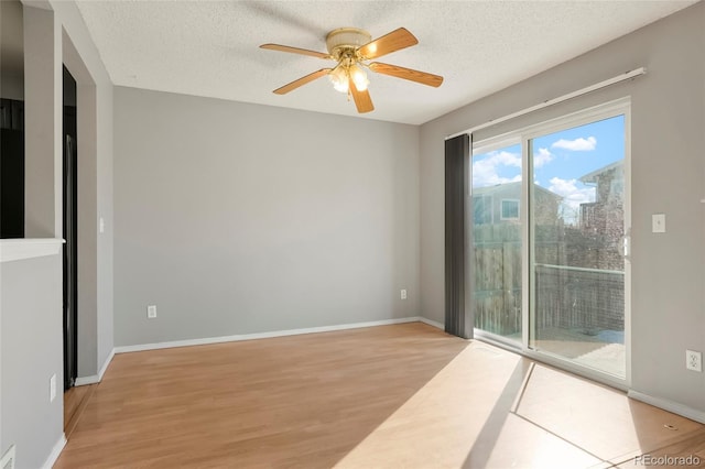 empty room with ceiling fan, light hardwood / wood-style flooring, and a textured ceiling