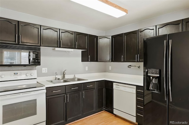 kitchen with sink, light wood-type flooring, and black appliances