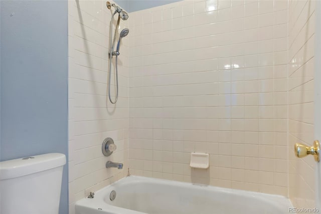 bathroom featuring tiled shower / bath combo and toilet