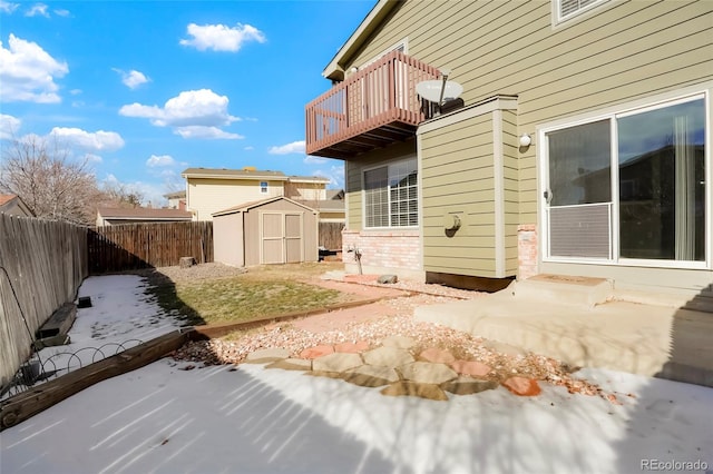 rear view of house featuring a balcony, a storage shed, and a patio area