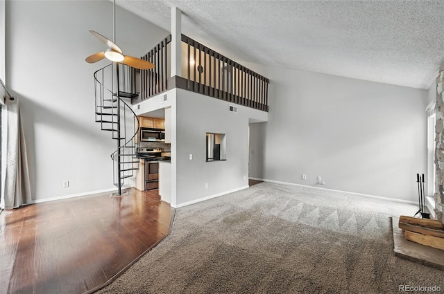 9797 E Peakview Ave Unit C10, Englewood, CO 80111 - unfurnished living room with a textured ceiling, a ceiling fan, stairs, high vaulted ceiling, and baseboards