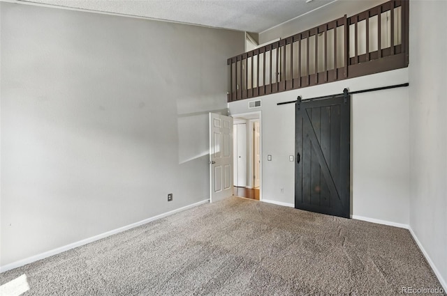 9797 E Peakview Ave Unit C10, Englewood, CO 80111 - unfurnished bedroom with carpet flooring, high vaulted ceiling, a barn door, baseboards, and a textured ceiling