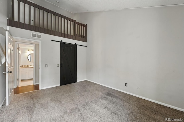 9797 E Peakview Ave Unit C10, Englewood, CO 80111 - unfurnished bedroom with a barn door, carpet, lofted ceiling, and baseboards