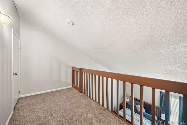 9797 E Peakview Ave Unit C10, Englewood, CO 80111 - hall featuring a textured ceiling, lofted ceiling, carpet, and baseboards