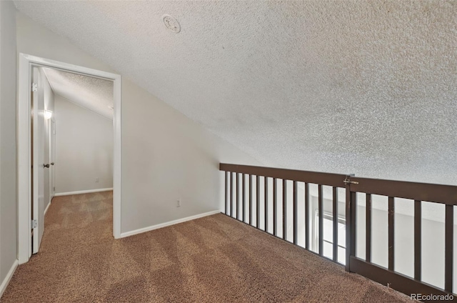 9797 E Peakview Ave Unit C10, Englewood, CO 80111 - hallway featuring a textured ceiling, carpet flooring, vaulted ceiling, and baseboards