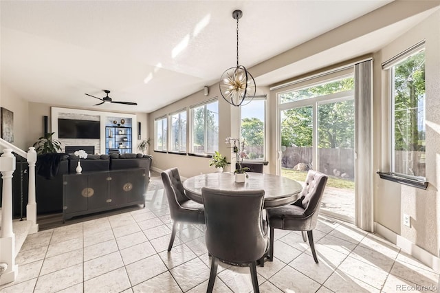 12693 W 82nd Ln, Arvada, CO 80005 - dining room with light tile patterned floors, a fireplace, and a ceiling fan