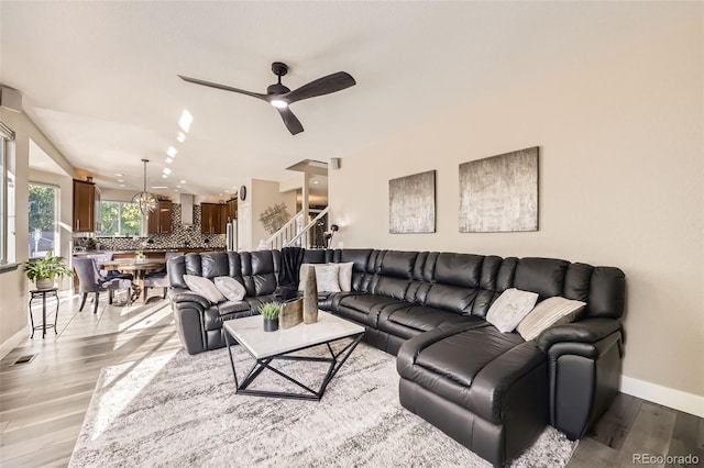 12693 W 82nd Ln, Arvada, CO 80005 - living room featuring baseboards, light wood-style floors, ceiling fan, and stairs